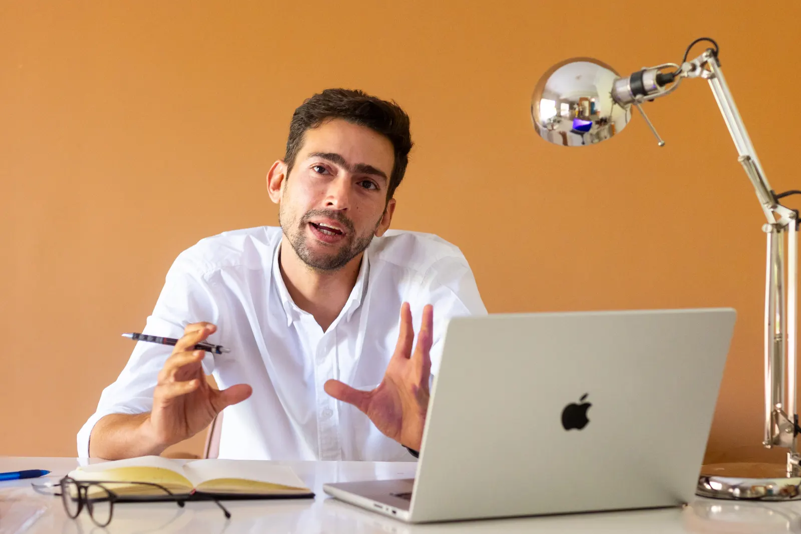 Yousef Elbarry at his desk with a laptop and sketchbook